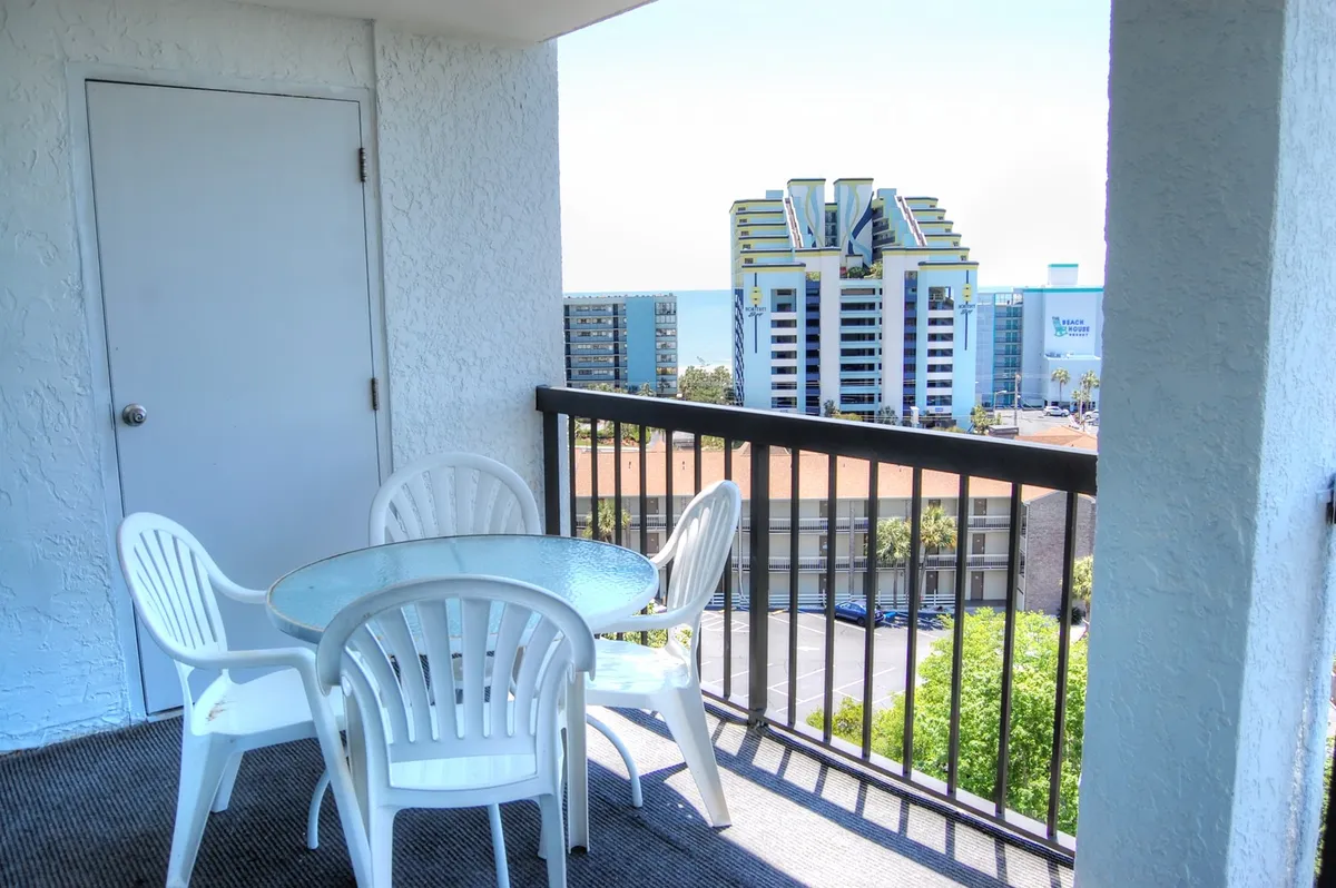 This exterior shot focuses on the private balcony, featuring a table and chairs overlooking the ocean. The setup encourages morning coffees, evening chats, and gatherings with loved ones, all while surrounded by the soothing sounds and sights of the Atlantic.